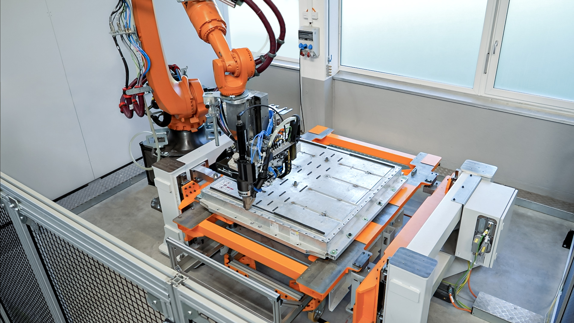 Robot industriel Liebherr LHDismantle réalisant le démontage automatisé d'une batterie haute tension de véhicule électrique.